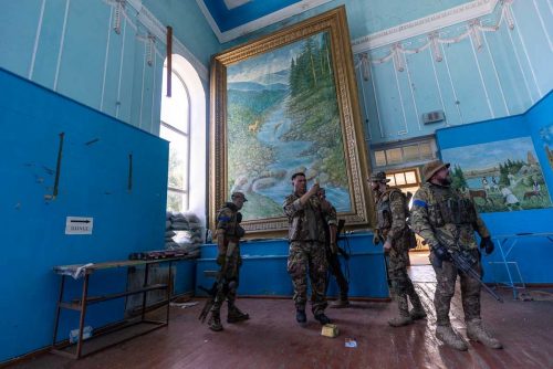 Ukraine, September 2022. A team of the Ukranian volunteer army visits the interior of the house of culture in Izyum where the Russians had installed their central command for months of occupation. After their rapid retreat, the Ukranian soldiers find numerous remains of the Russian staySoldiers from the Ukrainian volunteer army walk in front among the ruins of the city of IzyumThe Ukrainian city of Izium (Izyum) is related  with the mass burial site discovered near by. But there are people still living there. Russia heavily bombarded the town. In  September, its forces left the area leaving behind destroyed infrastructure and a population with no food and no water and under shock.