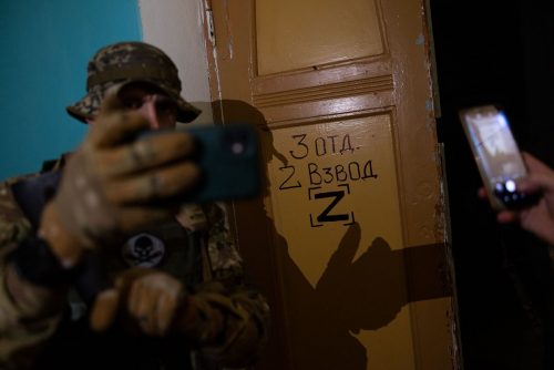 Ukraine, September 2022. A team of the Ukranian volunteer army visits the interior of the house of culture in Izyum where the Russians had installed their central command for months of occupation. After their rapid retreat, the Ukranian soldiers find numerous remains of the Russian staySoldiers from the Ukrainian volunteer army walk in front among the ruins of the city of IzyumThe Ukrainian city of Izium (Izyum) is related  with the mass burial site discovered near by. But there are people still living there. Russia heavily bombarded the town. In  September, its forces left the area leaving behind destroyed infrastructure and a population with no food and no water and under shock.
