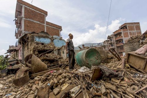 Nepal, 18 may 2015.A man stands on what is left of his house in  Dharmasthali.