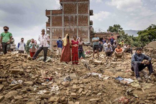 Nepal, 18 may 2015.People watching how a boldozer is pulling down what is left of their home. in Dharmasthali.