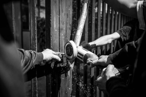 Rome, Italy, apr,2014.A group of homeless breaks the chains that are blocking the entrance to an abandoned building. A group of homeless from both Italian and non-EU countries occupy an abandoned building that up to nine months ago belong to the offices of the National Social Security Institute (INPS).Un gruppo di senza casa sia italiani che provenienti da paesi extracomunitari occupano un edificio abbandonato che fino a 9 mesi fa era la sede di uffici dell Istituto Nazionale della Previdenza Sociale (INPS).